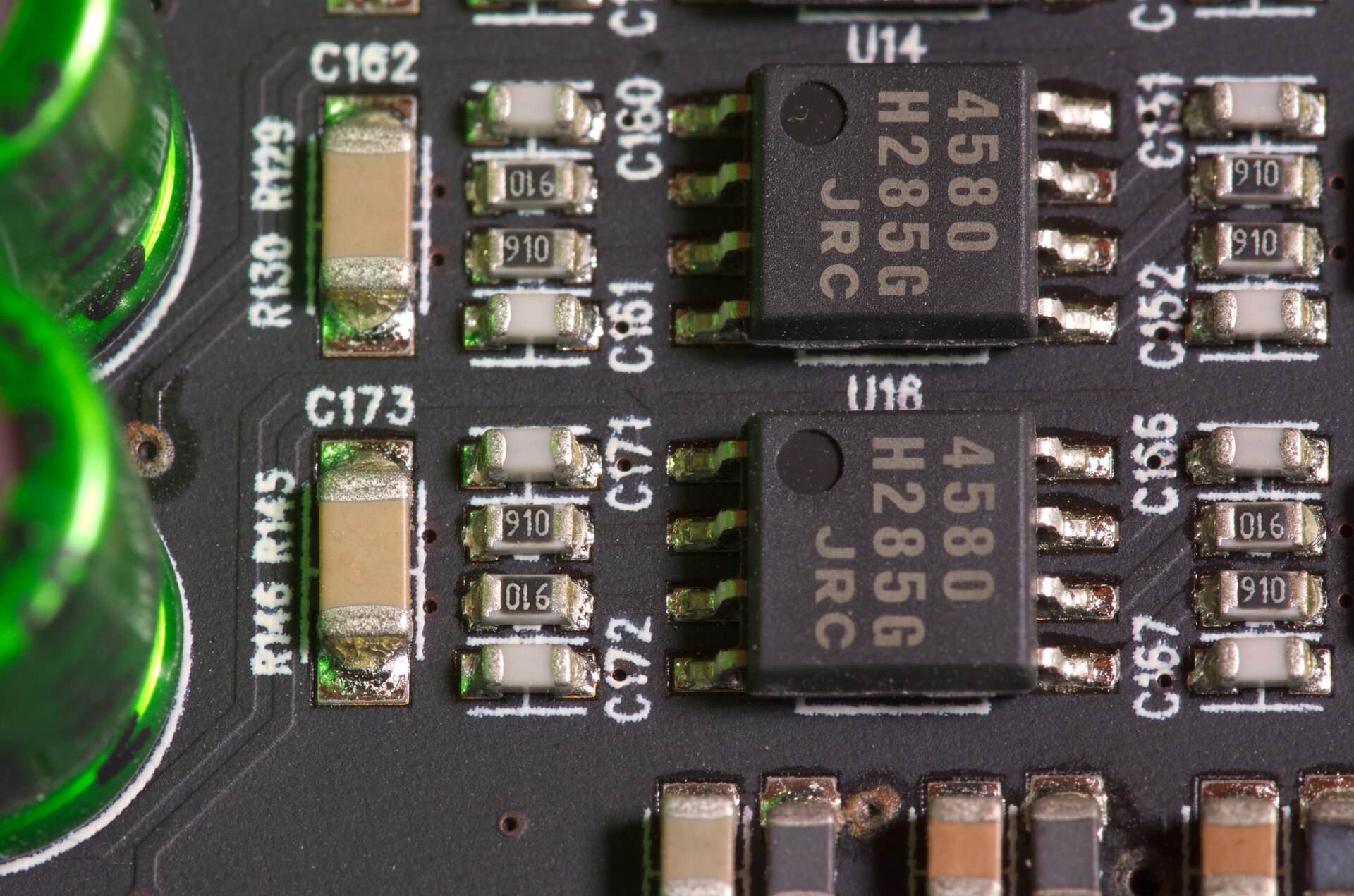 Macro view of a black sound-card circuit board with green highlights